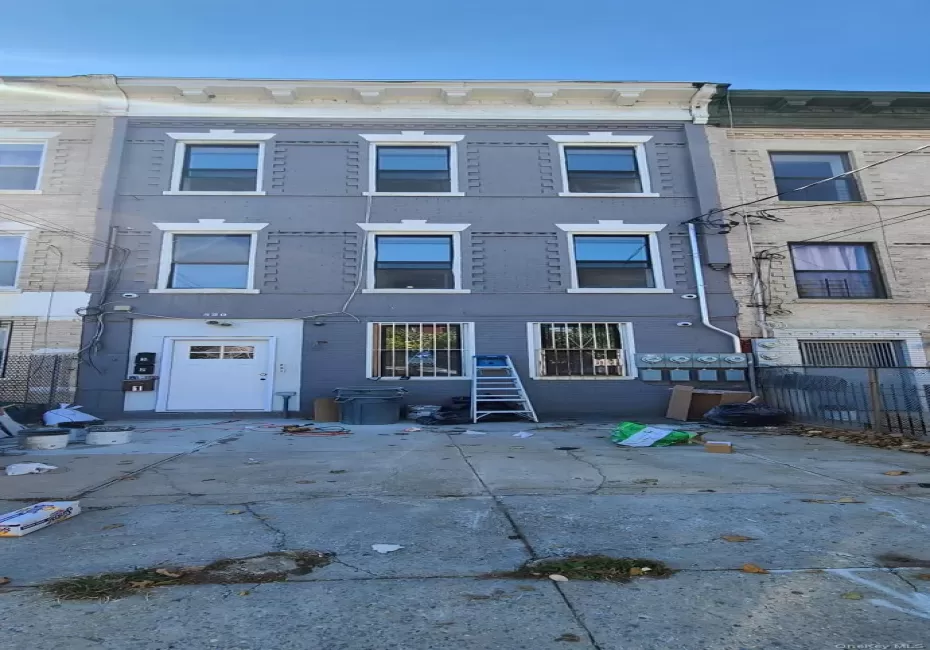 Three-story building with a gray facade and white architectural trim Three-story building with a gray facade and white architectural trim
