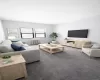 Living room with dark colored carpet and radiator heating unit Living room with dark colored carpet and radiator heating unit