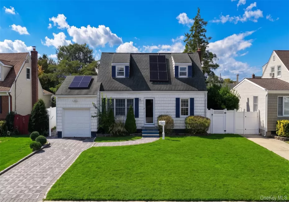 White-sided residence with a dark shingle roof featuring multiple solar panels White-sided residence with a dark shingle roof featuring multiple solar panels