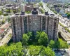 Multi-story building with a brick exterior, multiple balconies, and integrated green spaces Multi-story building with a brick exterior, multiple balconies, and integrated green spaces