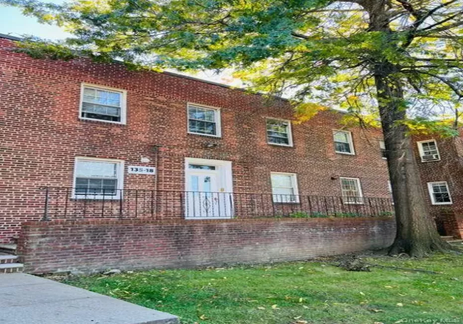 Brick exterior construction with multiple windows, a white entry door, and a black wrought iron railing Brick exterior construction with multiple windows, a white entry door, and a black wrought iron railing