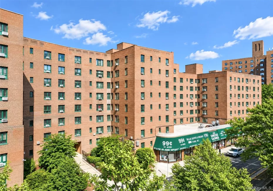 Multi-story brick exterior featuring a recessed building entrance and ground-level commercial storefront Multi-story brick exterior featuring a recessed building entrance and ground-level commercial storefront