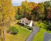 Split-level residence featuring a multi-tone exterior, asphalt driveway, two attached garage bays, roof-mounted skylights, and a wood privacy fence Split-level residence featuring a multi-tone exterior, asphalt driveway, two attached garage bays, roof-mounted skylights, and a wood privacy fence