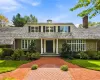 Stone and clapboard exterior featuring a covered entryway with columns, a shingled roof with a chimney, and a multi-patterned brick walkway Stone and clapboard exterior featuring a covered entryway with columns, a shingled roof with a chimney, and a multi-patterned brick walkway