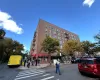 Multi-story brick exterior building featuring a corner lot orientation, integrated fire escapes, and ground-level commercial space with red awnings Multi-story brick exterior building featuring a corner lot orientation, integrated fire escapes, and ground-level commercial space with red awnings