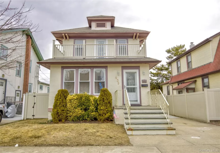 View of front of property with stucco siding, a balcony, a shingled roof, and fence View of front of property with stucco siding, a balcony, a shingled roof, and fence