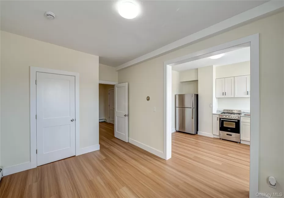 Unfurnished living room featuring light wood-style flooring and baseboards Unfurnished living room featuring light wood-style flooring and baseboards