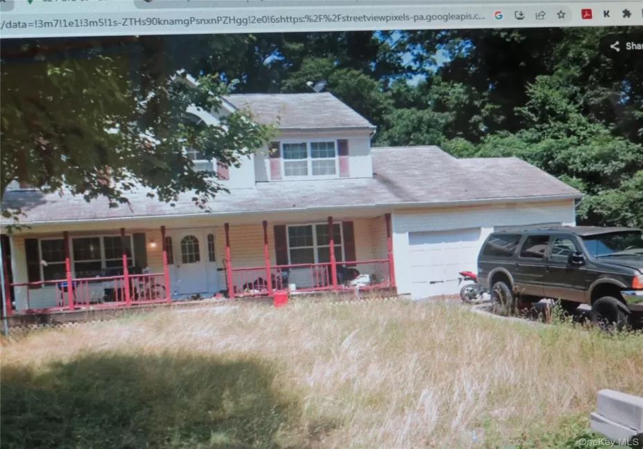 Two-story exterior featuring light-colored siding, a covered front porch with red railing, and an attached garage Two-story exterior featuring light-colored siding, a covered front porch with red railing, and an attached garage