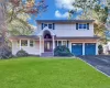Two-story exterior featuring shake-style siding, a covered arched entryway, a double-car garage, and multi-pane windows with decorative shutters Two-story exterior featuring shake-style siding, a covered arched entryway, a double-car garage, and multi-pane windows with decorative shutters