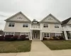 View of front of property featuring a front lawn, a balcony, driveway, and covered porch View of front of property featuring a front lawn, a balcony, driveway, and covered porch