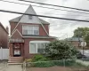 Brick exterior featuring a steep-pitched gable roof, front entrance awning, arched masonry detailing, and white siding accents Brick exterior featuring a steep-pitched gable roof, front entrance awning, arched masonry detailing, and white siding accents