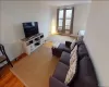 Living area featuring wood-finish flooring and three windows with metal frames Living area featuring wood-finish flooring and three windows with metal frames