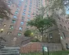 Multi-story brick exterior featuring structured masonry, recessed window placements, integrated black metal railings, stone stairs, and established perimeter landscaping Multi-story brick exterior featuring structured masonry, recessed window placements, integrated black metal railings, stone stairs, and established perimeter landscaping