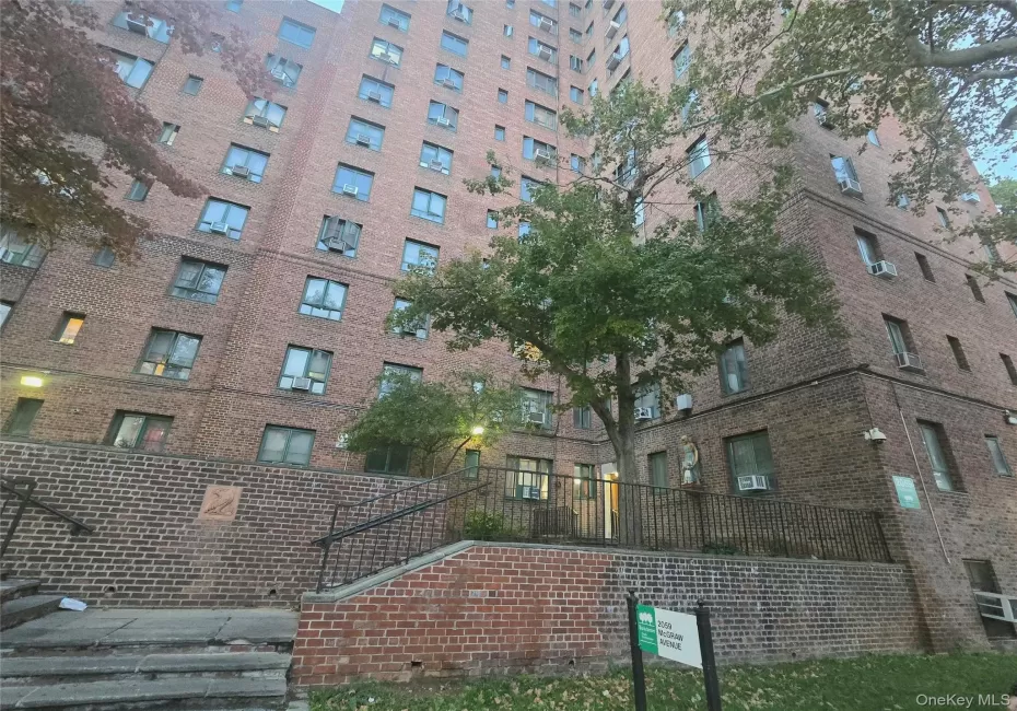 Multi-story brick exterior featuring structured masonry, recessed window placements, integrated black metal railings, stone stairs, and established perimeter landscaping Multi-story brick exterior featuring structured masonry, recessed window placements, integrated black metal railings, stone stairs, and established perimeter landscaping