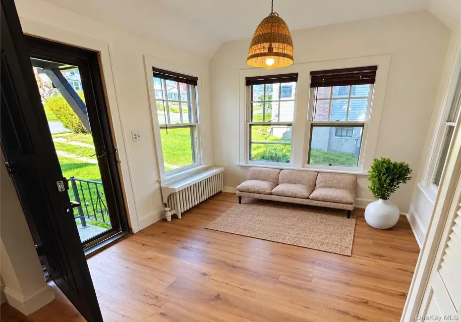 Virtually Staged. Doorway featuring radiator, light hardwood / wood-style floors, and plenty of natural light Virtually Staged. Doorway featuring radiator, light hardwood / wood-style floors, and plenty of natural light