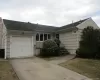 Single story home with a shingled roof, an attached garage, and driveway Single story home with a shingled roof, an attached garage, and driveway