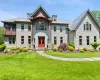 View of front facade featuring a front yard, a shingled roof, and french doors View of front facade featuring a front yard, a shingled roof, and french doors