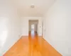 Interior space featuring wood-finish flooring, white walls, and a ceiling-mounted light fixture. Interior space featuring wood-finish flooring, white walls, and a ceiling-mounted light fixture.