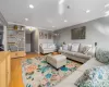 Living area featuring wood-finish flooring, recessed lighting, and built-in shelving with lower cabinetry Living area featuring wood-finish flooring, recessed lighting, and built-in shelving with lower cabinetry