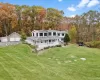 Rear view of house featuring a trampoline, a detached garage, a porch, an outdoor structure, and a chimney Rear view of house featuring a trampoline, a detached garage, a porch, an outdoor structure, and a chimney