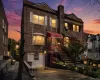 Brick facade residence featuring a prominent bay window with white shutters, a red alluminum awning, and a stone-lined planter bed Brick facade residence featuring a prominent bay window with white shutters, a red alluminum awning, and a stone-lined planter bed