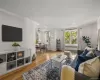 Living room with radiator, plenty of natural light, light wood-type flooring, and ceiling fan Living room with radiator, plenty of natural light, light wood-type flooring, and ceiling fan