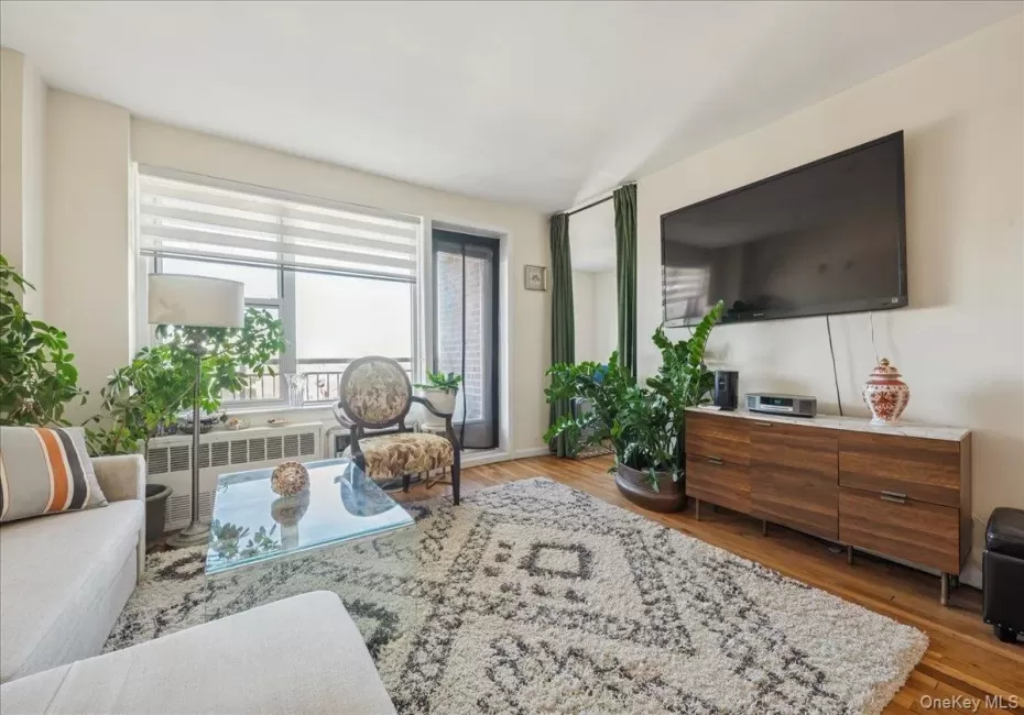 Living room with wood finished floors and radiator heating unit Living room with wood finished floors and radiator heating unit