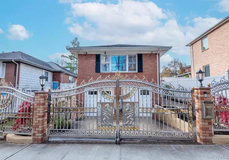 View of front facade with a gate and brick siding View of front facade with a gate and brick siding