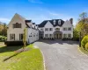 Traditional home featuring asphalt driveway, a front lawn, and a chimney Traditional home featuring asphalt driveway, a front lawn, and a chimney