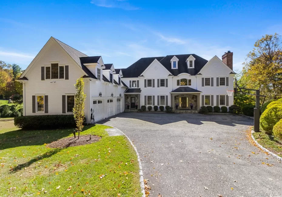 Traditional home featuring asphalt driveway, a front lawn, and a chimney Traditional home featuring asphalt driveway, a front lawn, and a chimney