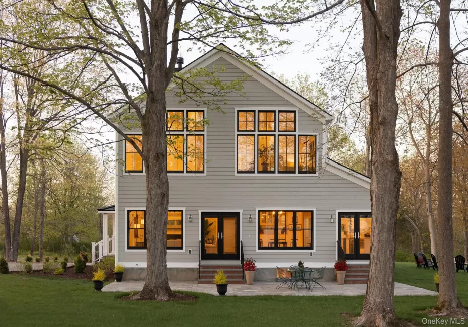 Southern side of the home with patio, two sets of patio doors, and extensive windows Southern side of the home with patio, two sets of patio doors, and extensive windows