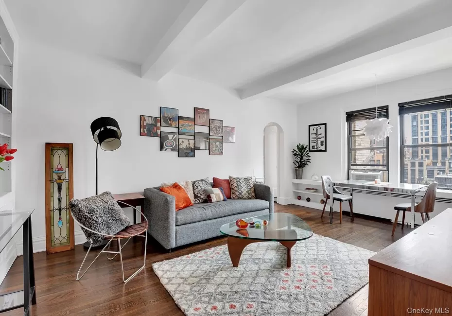 Living area featuring beamed ceiling, arched walkways, and wood floors Living area featuring beamed ceiling, arched walkways, and wood floors