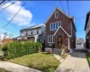 Brick residence featuring a gabled roofline, arched entry door, multiple window configurations, concrete driveway, and a detached garage Brick residence featuring a gabled roofline, arched entry door, multiple window configurations, concrete driveway, and a detached garage