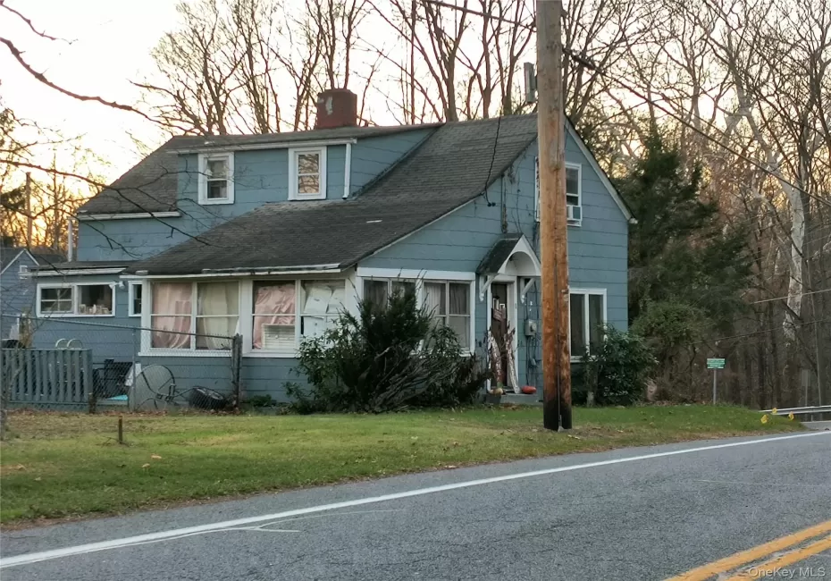 View of front facade featuring a chimney and a shingled roof View of front facade featuring a chimney and a shingled roof