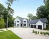 Modern inspired farmhouse with board and batten siding, gravel driveway, an attached garage, a standing seam roof, and roof with shingles Modern inspired farmhouse with board and batten siding, gravel driveway, an attached garage, a standing seam roof, and roof with shingles