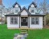View of front of property featuring a front lawn, roof with shingles, and board and batten siding View of front of property featuring a front lawn, roof with shingles, and board and batten siding