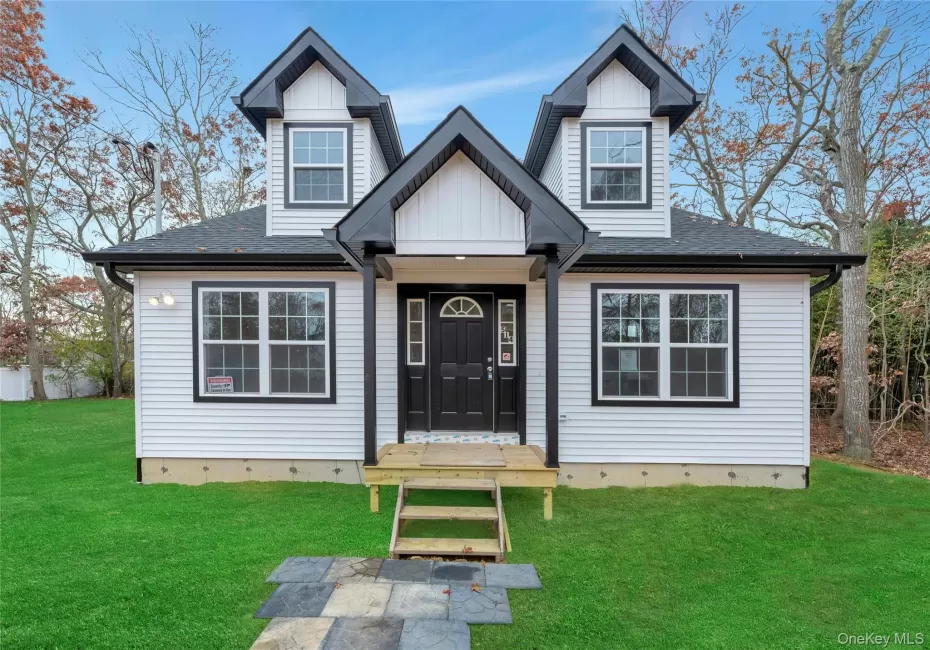 View of front of property featuring a front lawn, roof with shingles, and board and batten siding View of front of property featuring a front lawn, roof with shingles, and board and batten siding
