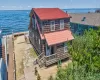 Waterfront residence featuring shingle siding and a red roof Waterfront residence featuring shingle siding and a red roof