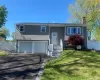 Split-level residence featuring gray shake siding and a two-car garage Split-level residence featuring gray shake siding and a two-car garage