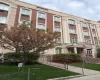 Multi-story building featuring brick and stucco facade, arched windows, and a prominent portico entry Multi-story building featuring brick and stucco facade, arched windows, and a prominent portico entry