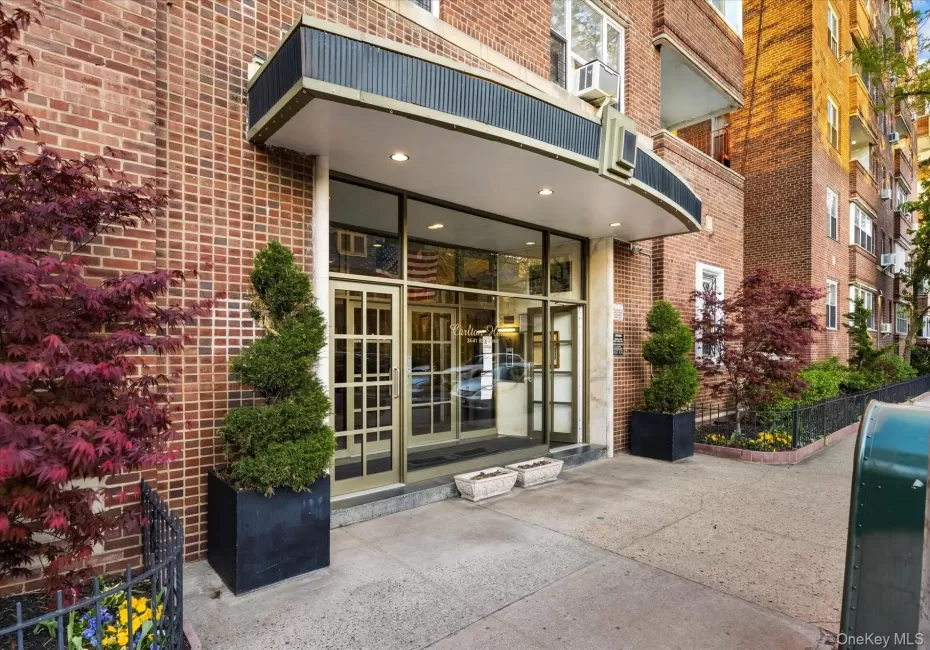 Brick facade building entry featuring a curved awning, glass double doors, sidelight windows, and recessed lighting Brick facade building entry featuring a curved awning, glass double doors, sidelight windows, and recessed lighting