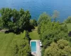 View from above of property with a pool and a nearby body of water View from above of property with a pool and a nearby body of water