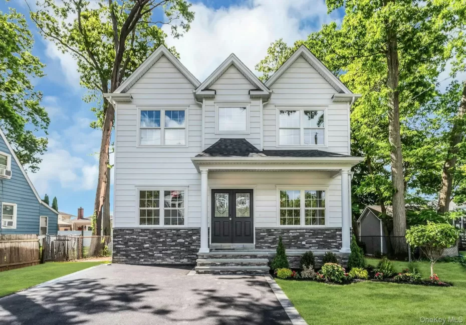 Contemporary NEw construciton two-story residence with white siding and a dark gray stone facade accent Contemporary NEw construciton two-story residence with white siding and a dark gray stone facade accent