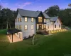 Side view of property at dusk featuring roof with shingles, a yard, and board and batten siding Side view of property at dusk featuring roof with shingles, a yard, and board and batten siding