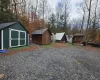 Gravel outdoor area featuring multiple sheds, a small A-frame structure, and a wooden gazebo Gravel outdoor area featuring multiple sheds, a small A-frame structure, and a wooden gazebo