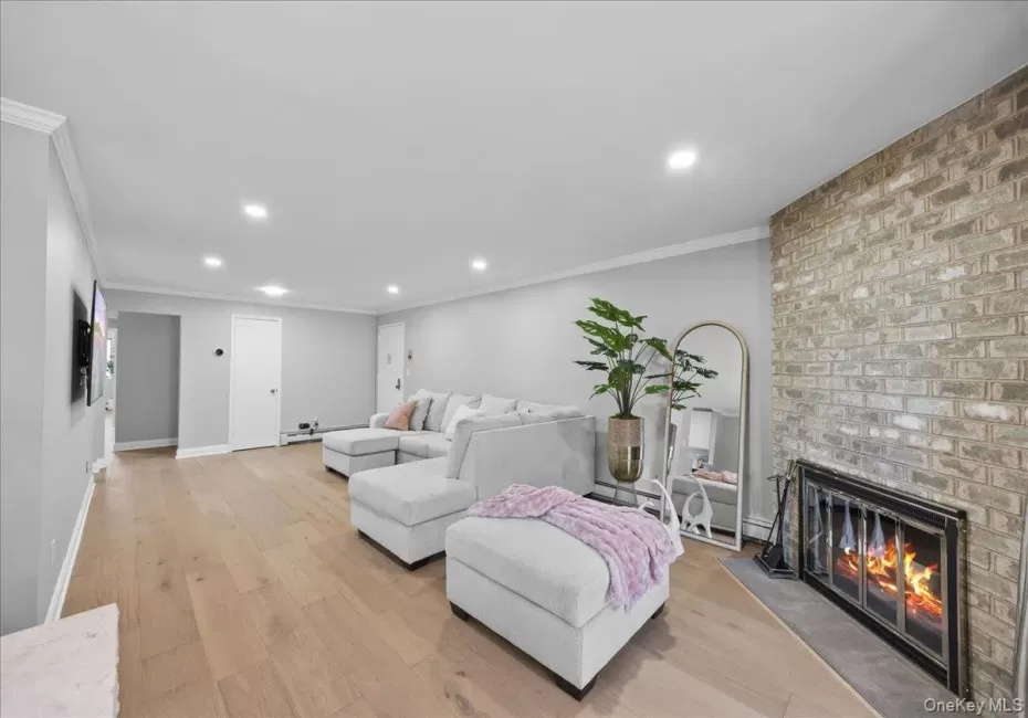 Living area featuring light-toned wood-finish flooring, recessed lighting, and crown molding Living area featuring light-toned wood-finish flooring, recessed lighting, and crown molding