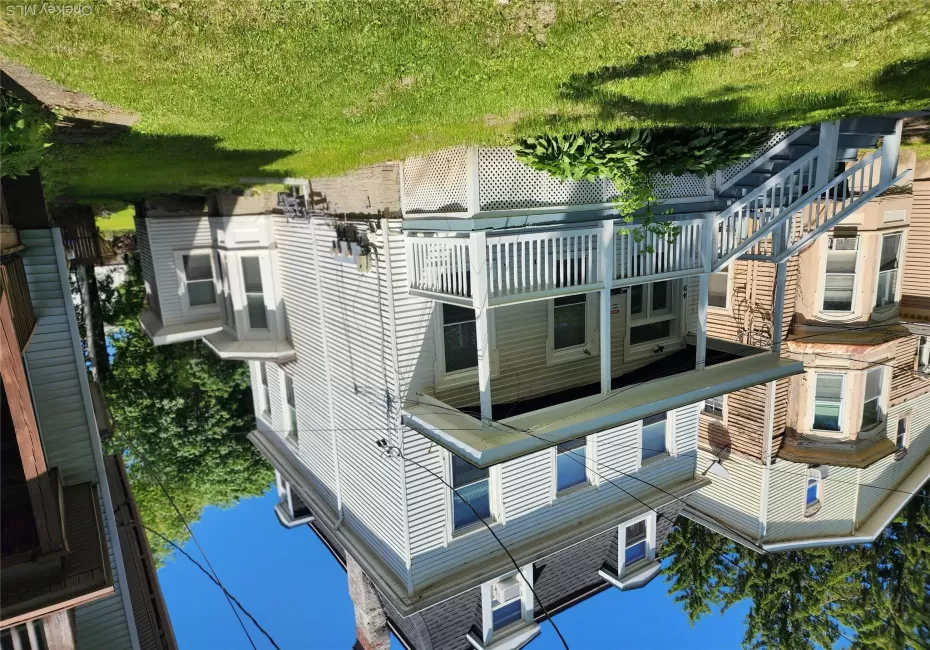 Two-story siding exterior with a slate-style gambrel roof and dormer windows Two-story siding exterior with a slate-style gambrel roof and dormer windows