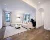 Living room featuring ornamental molding, arched walkways, wood-type flooring, and recessed lighting Living room featuring ornamental molding, arched walkways, wood-type flooring, and recessed lighting