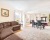 Living area with plenty of natural light, a chandelier, carpet floors, and baseboards Living area with plenty of natural light, a chandelier, carpet floors, and baseboards