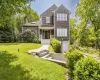 View of front of home featuring a front lawn, a porch, a chimney, and roof with shingles View of front of home featuring a front lawn, a porch, a chimney, and roof with shingles